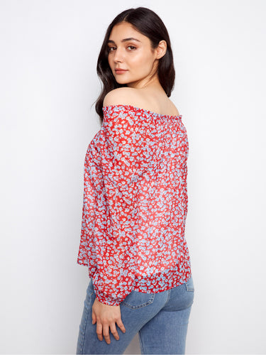Chic red blouse adorned with a vibrant floral pattern and elastic cuffs, creating a relaxed yet trendy ensemble by Charlie B.