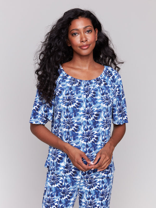 Blue top with short sleeves and floral pattern by Charlie B.