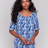 Blue top with short sleeves and floral pattern by Charlie B.