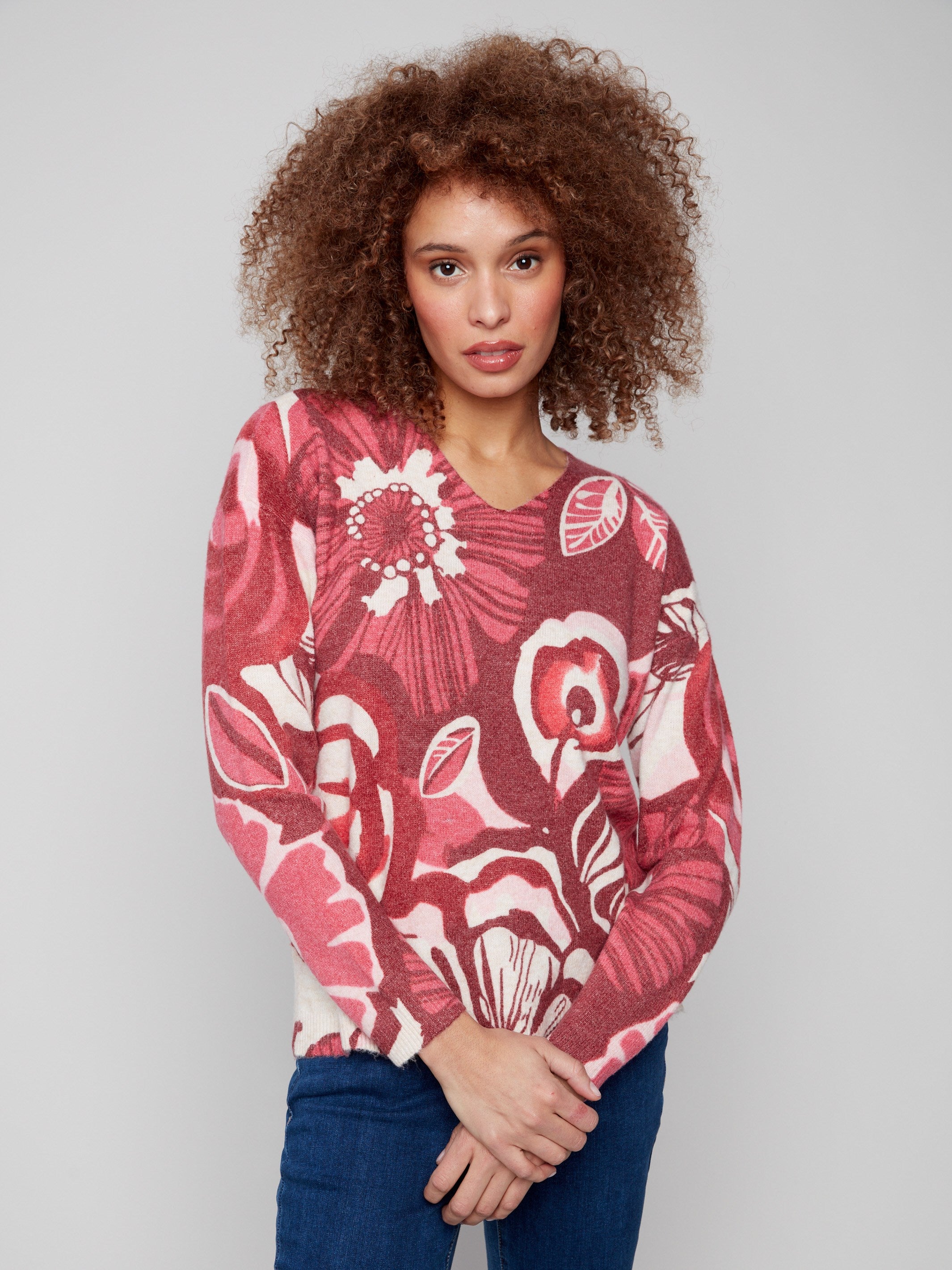 Elegant floral sweater with drop shoulders, blending red and pink tones beautifully by Charlie B.