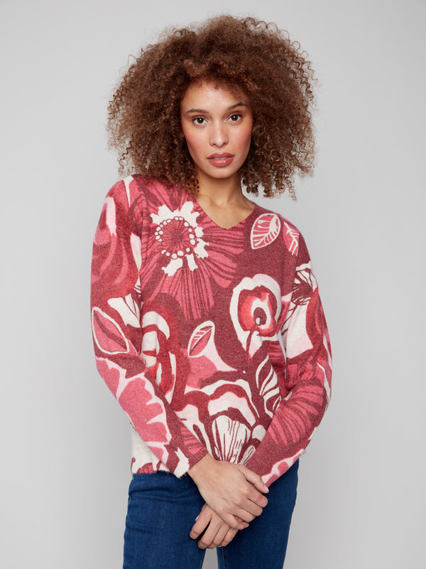 Elegant floral sweater with drop shoulders, blending red and pink tones beautifully by Charlie B.