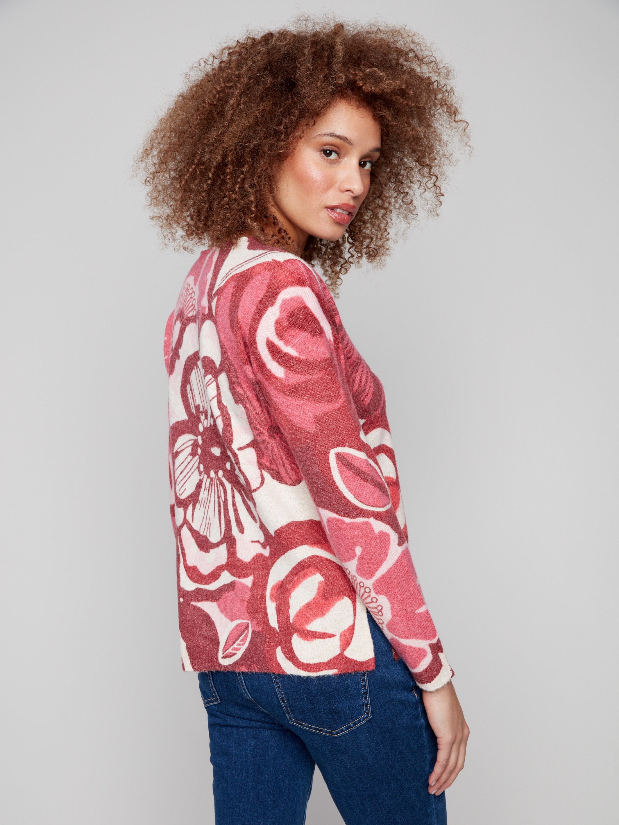 Stylish floral print sweater with side slits, offering comfort and flair in red and pink hues by Charlie B.
