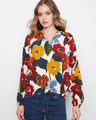 Floral blouse with a notch neckline, featuring vibrant colors and raglan sleeves. Crafted from soft viscose fabric by Charlie B.