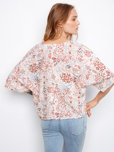 This printed blouse features short dolman sleeves, offering both elegance and ease of movement by Charlie B.