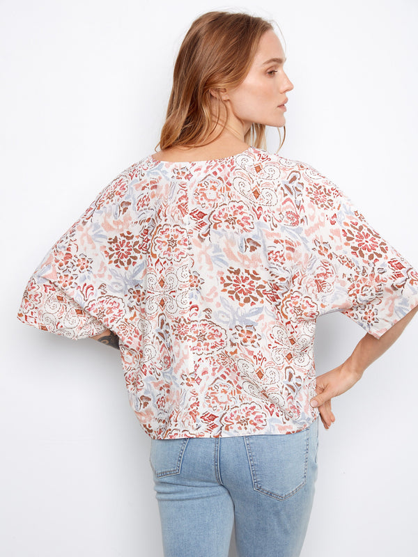 This printed blouse features short dolman sleeves, offering both elegance and ease of movement by Charlie B.