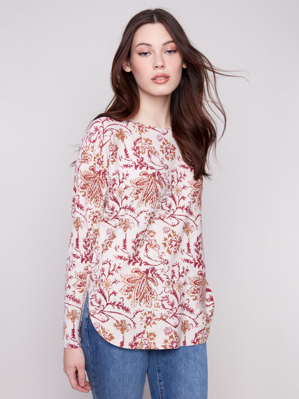 Calico sweater featuring a stylish boat neck and abstract floral design, complete with practical side pockets by Charlie B.