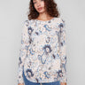 Blush sweater featuring a boat neck and abstract floral print, perfect for a chic look by Charlie B.
