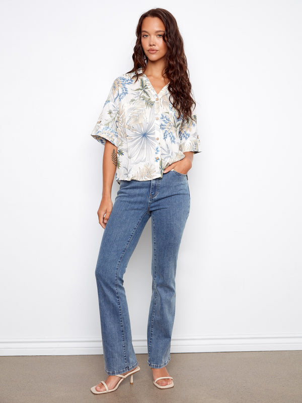 Short sleeve blouse featuring button tabs and chest pockets, showcasing a relaxed yet stylish look with floral patterns by Charlie B.