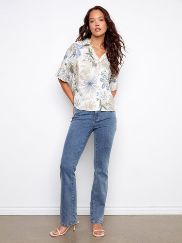 Elegant floral short sleeve blouse with button tabs and a crisp shirt collar, offering both style and comfort for any occasion by Charlie B.