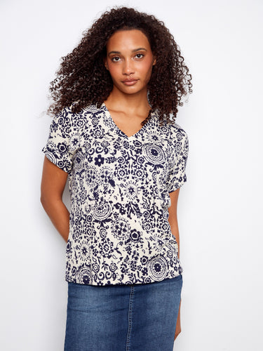 Elegant top showcasing a beautiful floral design with folded cuffs and crafted from soft linen blend fabric by Charlie B.