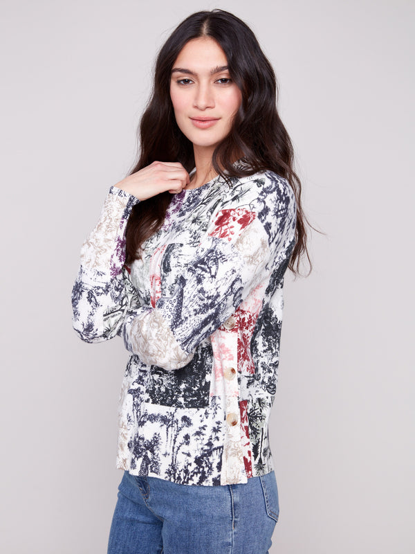 This long-sleeve sweater showcases a vibrant abstract Frame pattern with elegant side buttons by Charlie B.