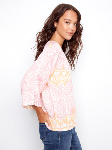 Elegant floral blouse featuring ladder stitch detail, adding a touch of sophistication to the casual look. Crafted by Charlie B.
