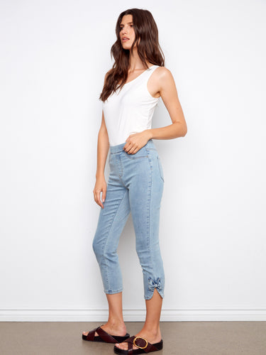 Adorned with a charming bow detail at the hem, these jeans add a playful touch. By Charlie B.