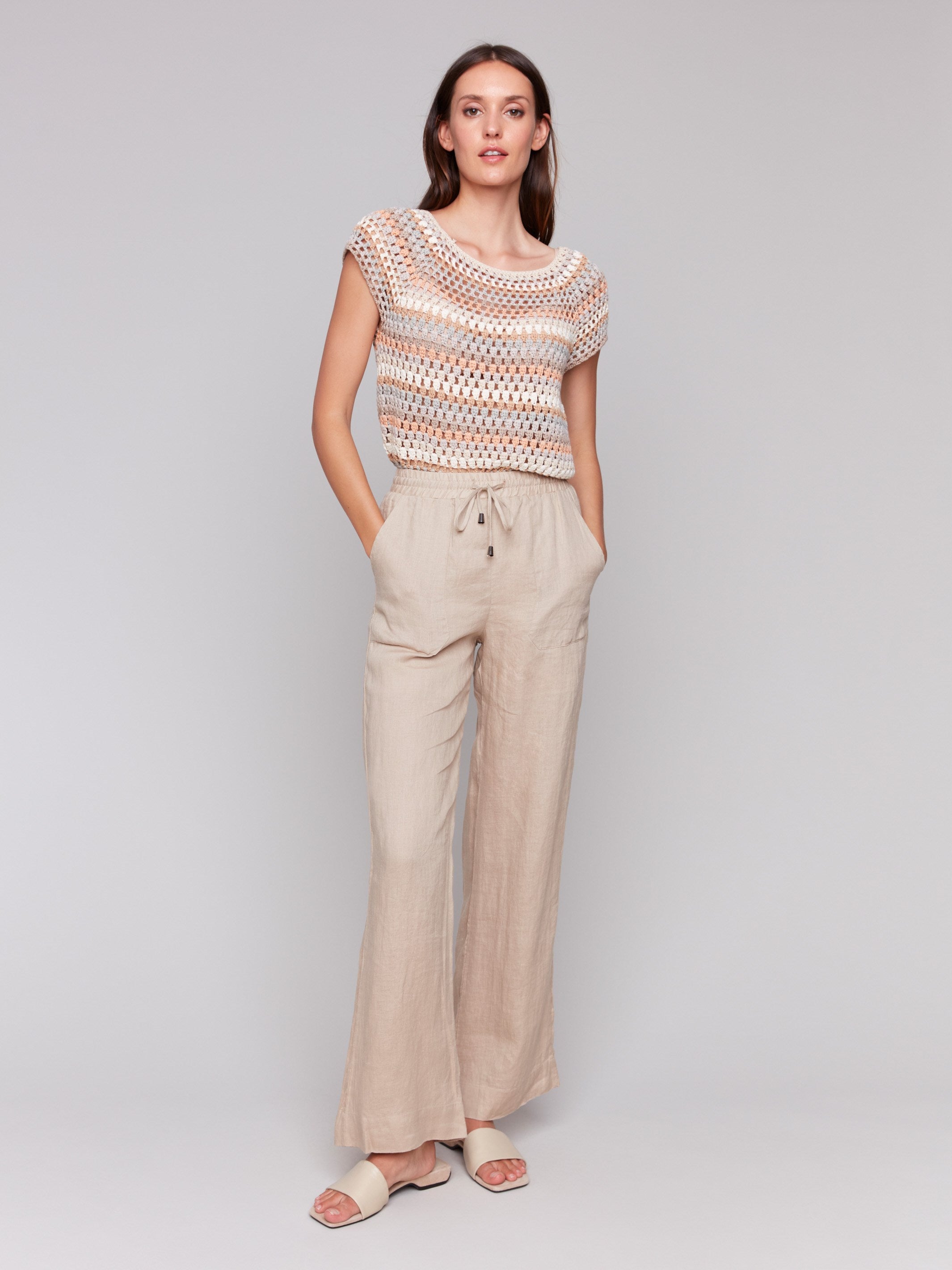 Biscuit-colored pants with a utility pocket design by Charlie B.