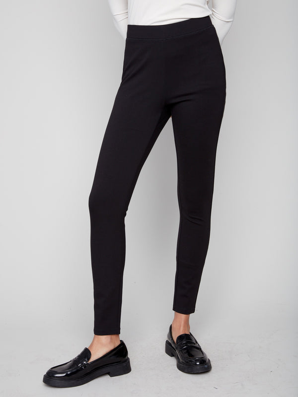 Elegant black pull-on pants with an elastic waistband, paired with a white top for chic comfort by Charlie B.