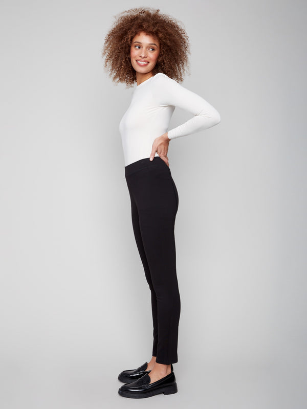 Stylish black pants showcasing back stitch detail and paired with a white top, perfect for versatile elegance by Charlie B.