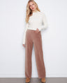 Taupe wide-leg corduroy pants in a full-length cut, paired with a white ribbed sweater by Charlie B.