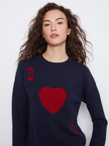 Elegant navy sweater showcasing drop shoulders and red heart details, styled effortlessly with light denim jeans by Charlie B.
