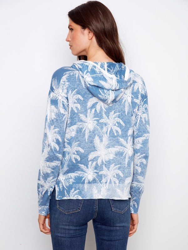 Versatile blue hoodie showcasing a charming reverse print of palm trees, complete with drawstring details. A must-have fashion piece by Charlie B.