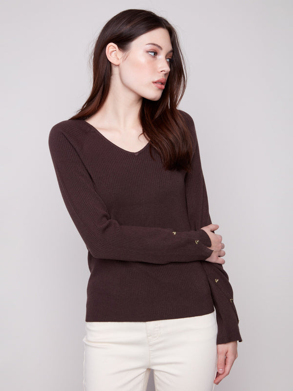 Classic mocha sweater designed with a sophisticated V-neck, ribbed detail, and eye-catching heart rivet accents by Charlie B.