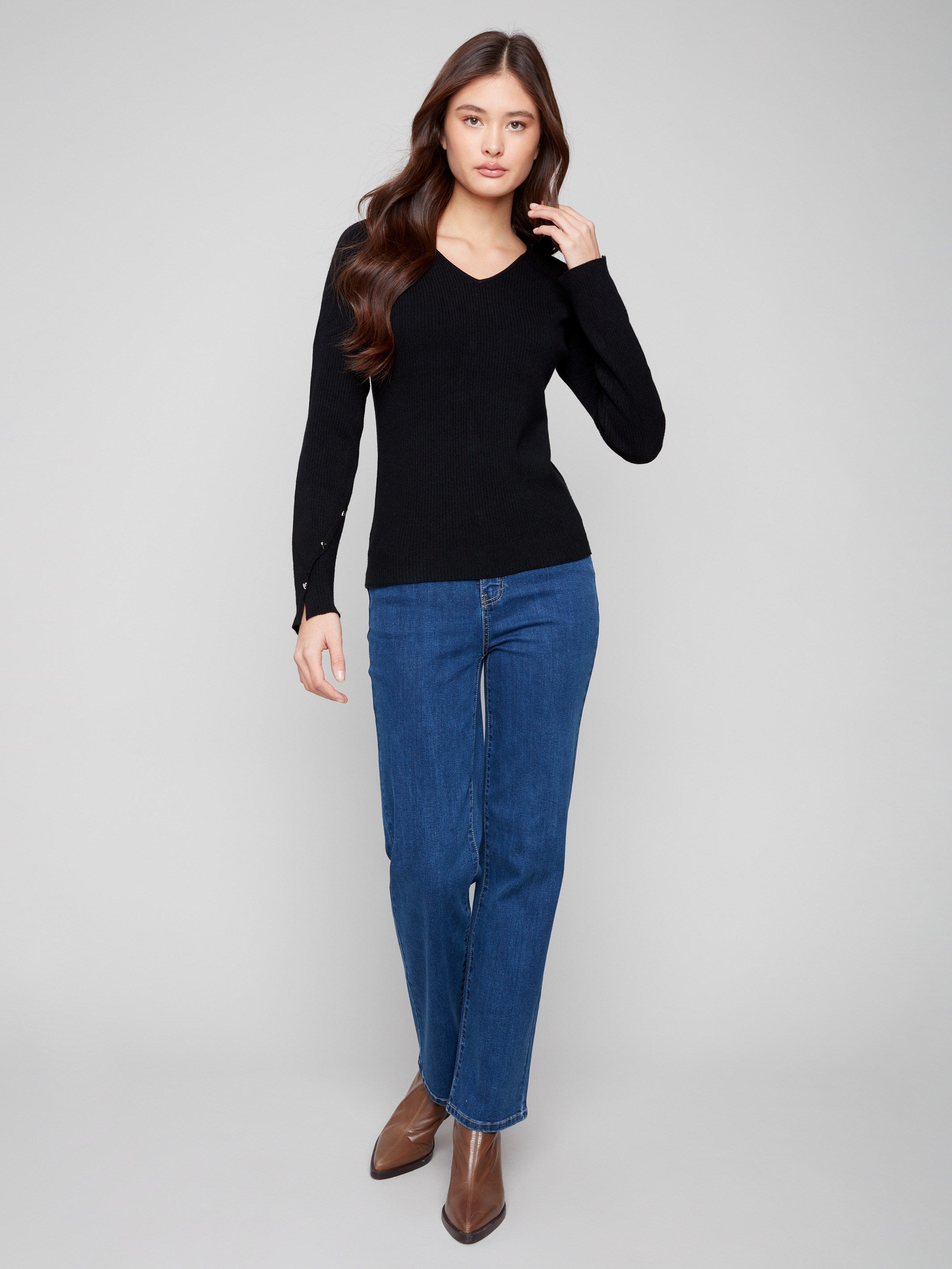Stylish black sweater adorned with heart rivets on the sleeves for added detail by Charlie B.