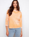 Orange top with a crew neckline, featuring a unique reversed print design. Made from 100% cotton for comfort. By Charlie B.