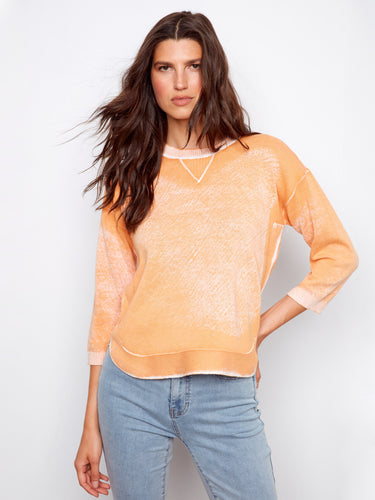Fashionable orange top showcasing a reversed print and easygoing style, made entirely of soft cotton fabric. By Charlie B.