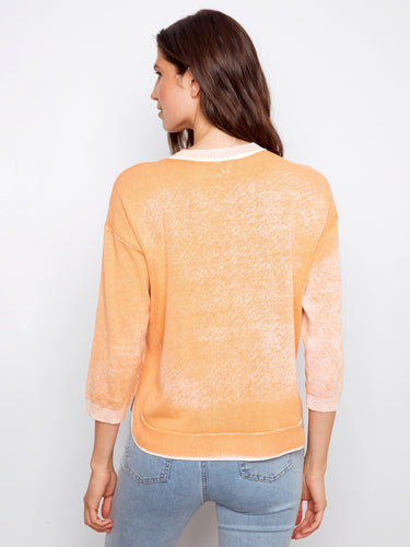 Elegant orange top with classic crew neckline and rounded hem, crafted from pure cotton for everyday wearability. By Charlie B.