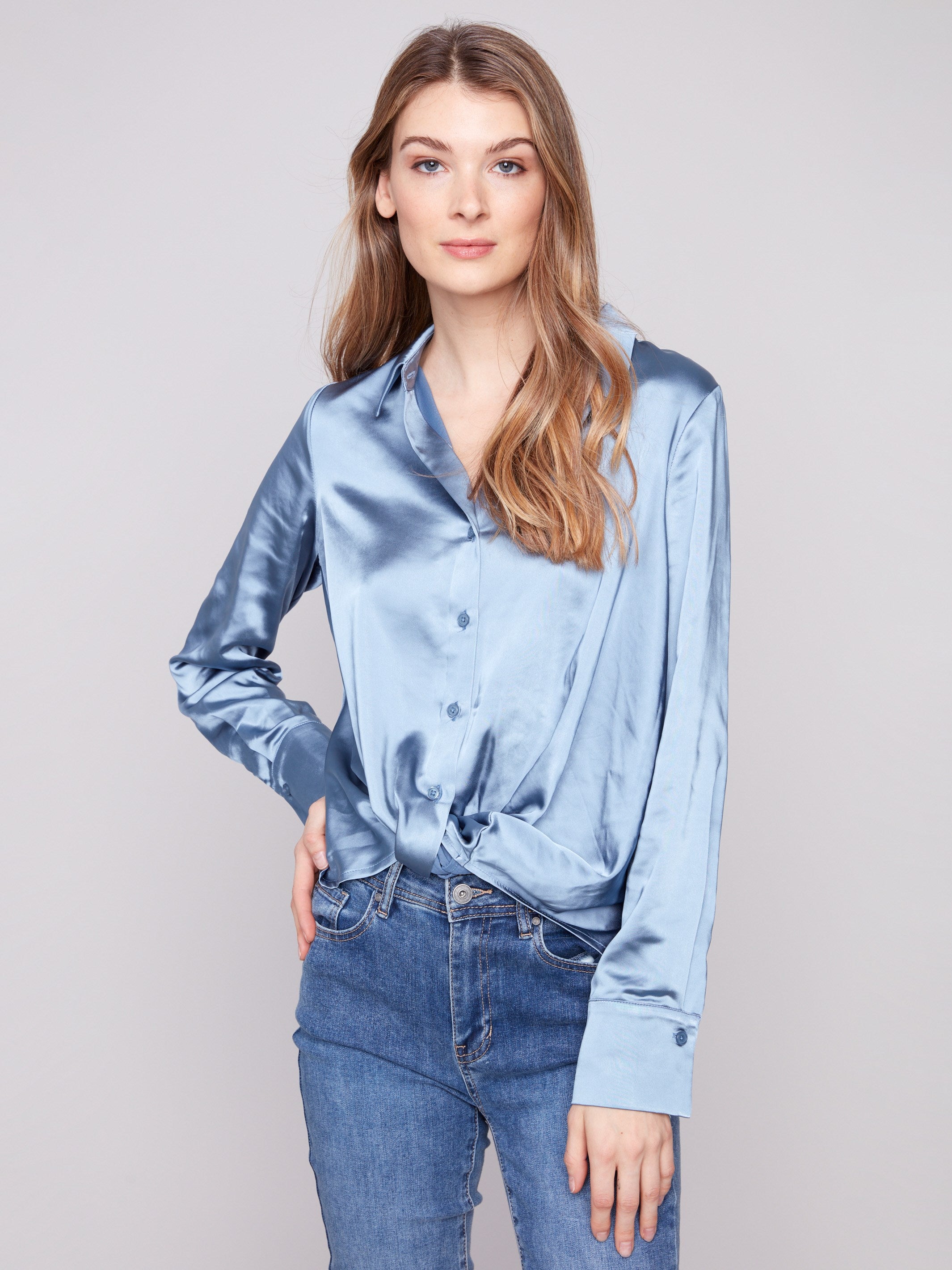 Stylish blue satin shirt with a unique twisted front detail and comfortable long sleeves by Charlie B.