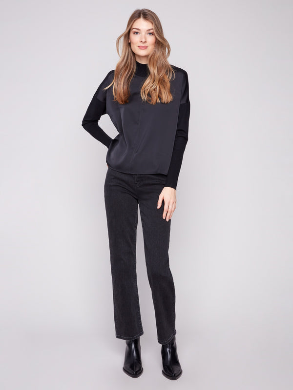 Stylish black top featuring a sleek front seam detail and ribbed cuffs for a modern look by Charlie B.