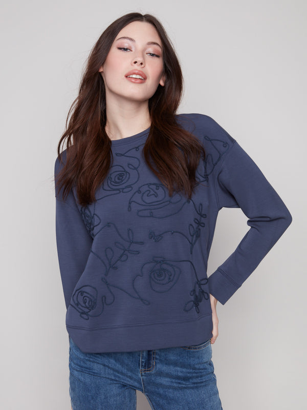 The intricate soutache design elevates the aesthetic of the Moonlight Scuba Knit Top, offering a chic appearance by Charlie B.