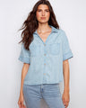 Light blue blouse with chest pockets and button tabs on short sleeves, crafted from Tencel by Charlie B.