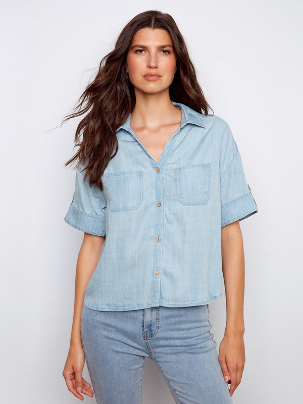 Light blue blouse with chest pockets and button tabs on short sleeves, crafted from Tencel by Charlie B.