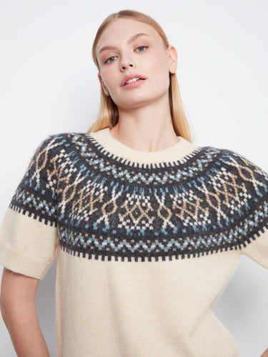 Short raglan sleeves on an ecru sweater adorned with intricate geometric patterns around the neckline by Charlie B.