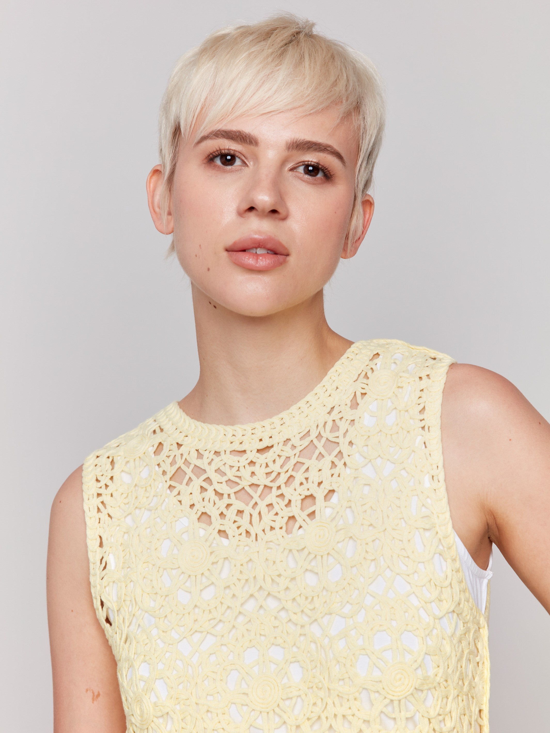 Charming lemonade sleeveless crochet top featuring a unique crew neckline by Charlie B.
