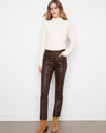 Coffee-colored slim leg pants with ankle length design, styled with a white top and boots by Charlie B.