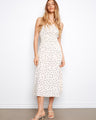 White dress with black polka dots, featuring a wide strap design and smocked waist by Charlie B.