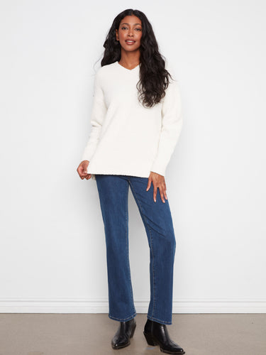 This ecru boucle sweater features long sleeves and a relaxed fit, offering both style and comfort for any occasion by Charlie B.