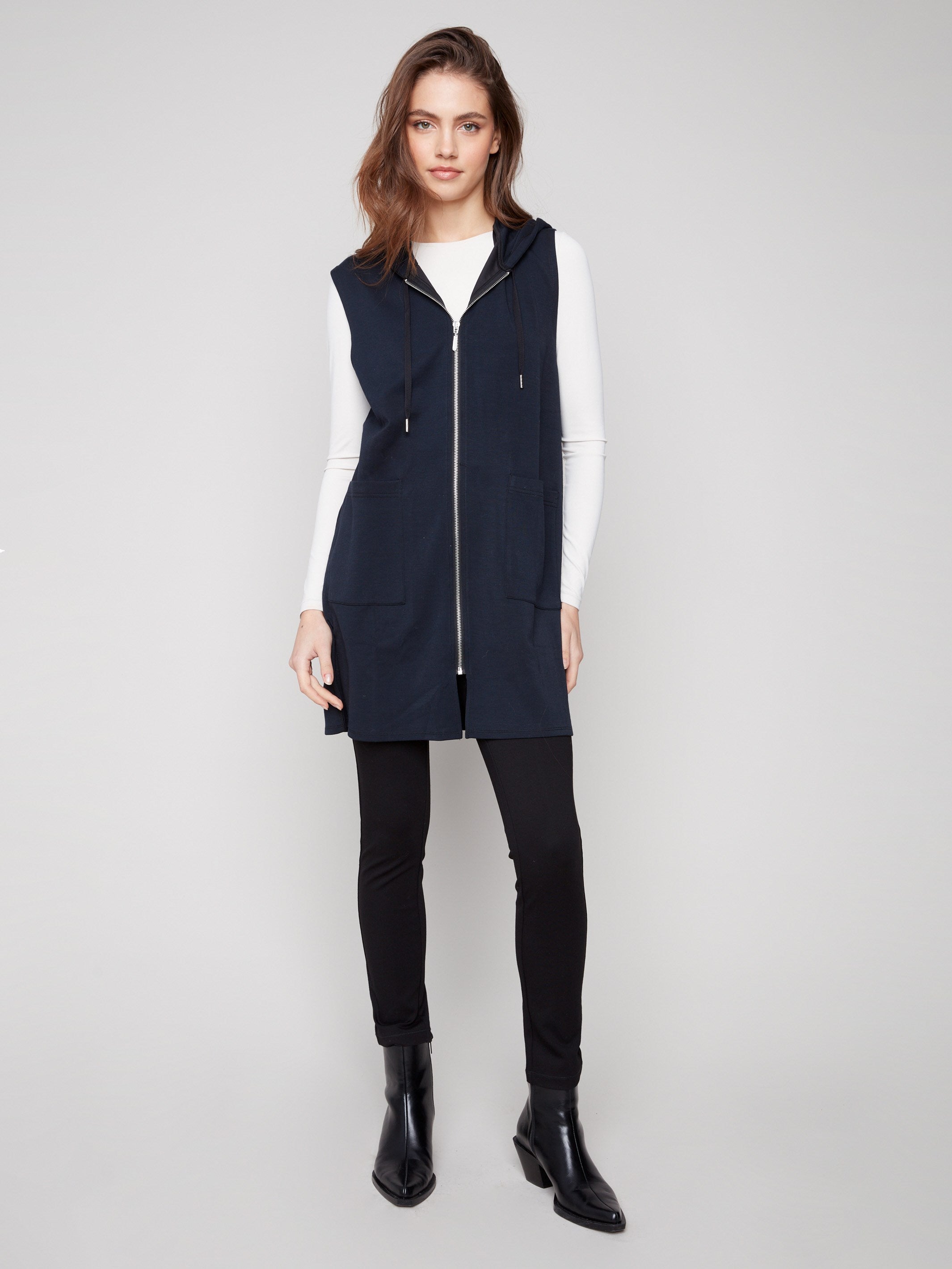 Black long sleeveless vest featuring mid-thigh length with a zip front and patch pockets by Charlie B.