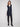 Black long sleeveless vest featuring mid-thigh length with a zip front and patch pockets by Charlie B.