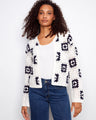 White crochet cardigan with a stylish crew neck and geometric patterns, perfect for layering by Charlie B.