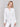 White stretch denim jacket with long sleeves and faux front pockets, featuring a button-up front by Charlie B.