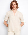 Light beige blouse featuring a henley neckline with subtle gold stripe accents by Charlie B.
