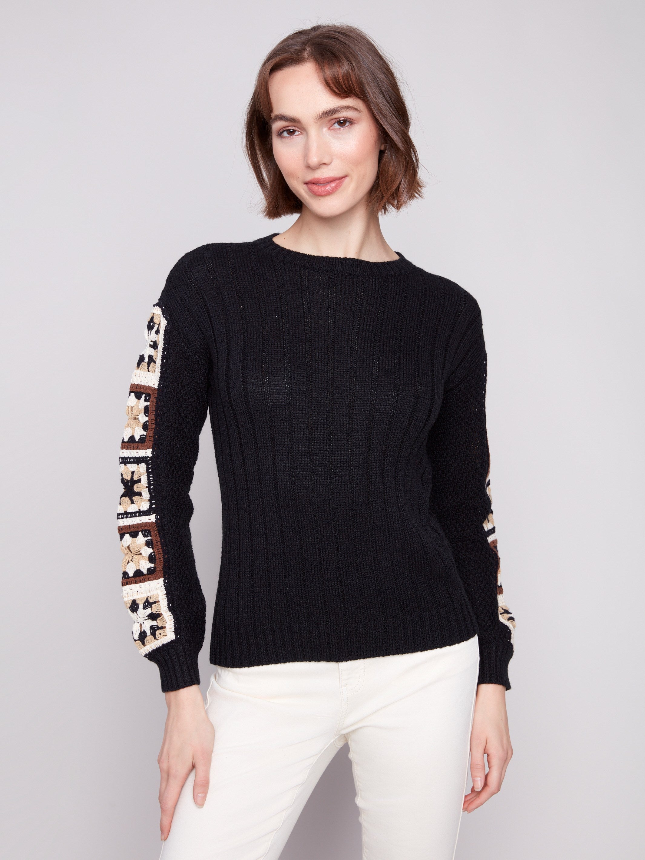 Elegant black sweater featuring crochet sleeves, perfect for a stylish look by Charlie B.