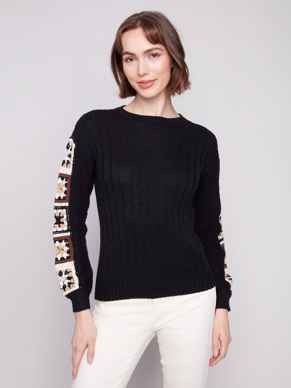Elegant black sweater featuring crochet sleeves, perfect for a stylish look by Charlie B.