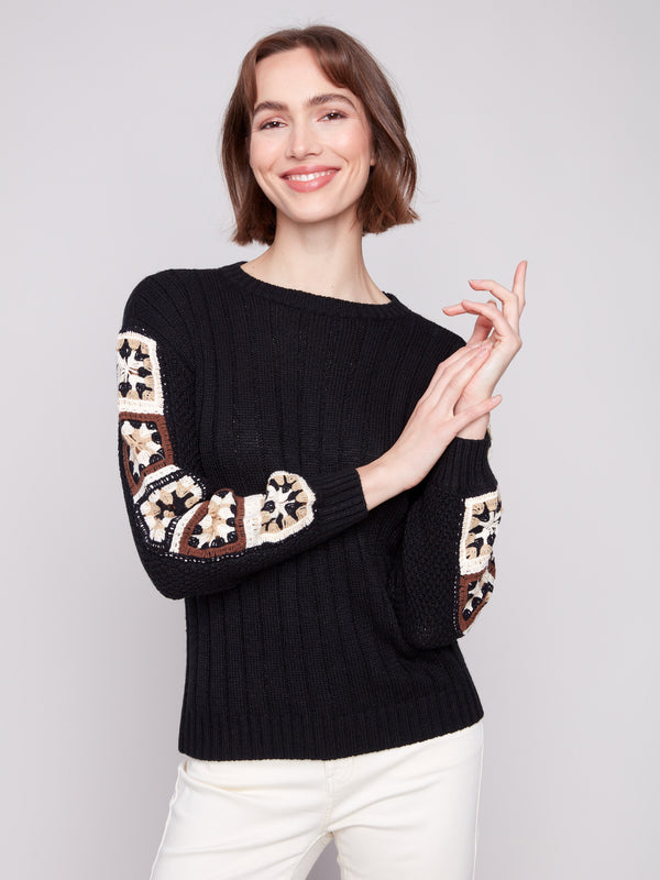 Chic black sweater with intricate crochet detailing, offering a unique style by Charlie B.