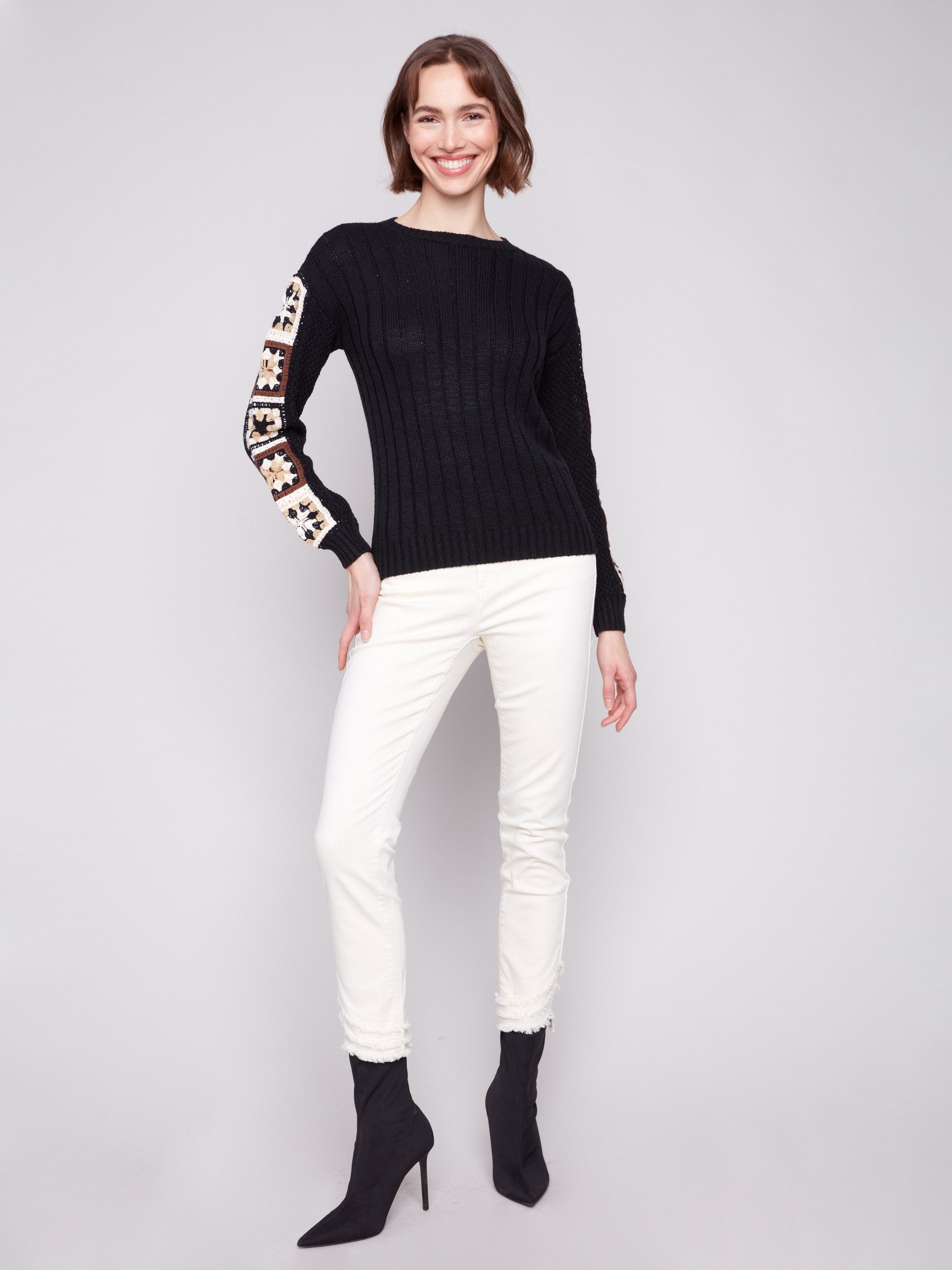 Stylish black sweater with drop shoulders and crochet accents for added flair by Charlie B.