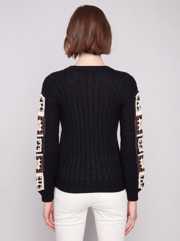 Classic black sweater highlighting the crew neckline and exquisite sleeve craftsmanship by Charlie B.