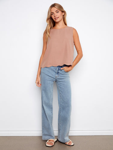 The scallop hem adds a touch of elegance to this casual top, making it versatile for both day and night looks. By Charlie B.