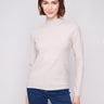 Oat sweater featuring a stylish mock neck, paired elegantly with blue jeans for a chic look by Charlie B.